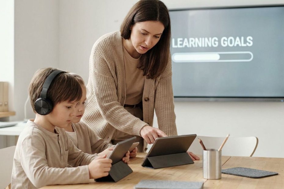 Teacher guiding students using laptops for focused classroom learning